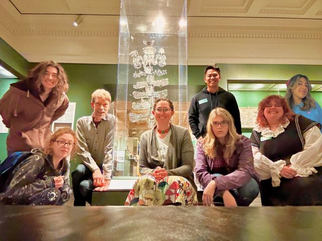 a group of students in front of a museum display or an ornate, branching mushroom