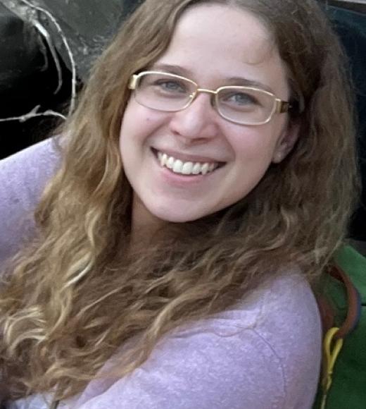 A woman wearing glasses smiling