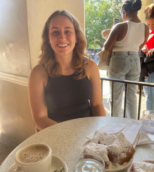 A Woman at a table with pastries and coffee