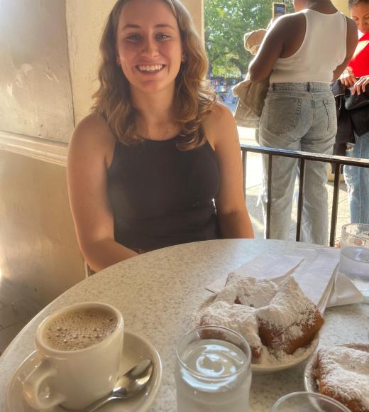 A Woman at a table with pastries and coffee