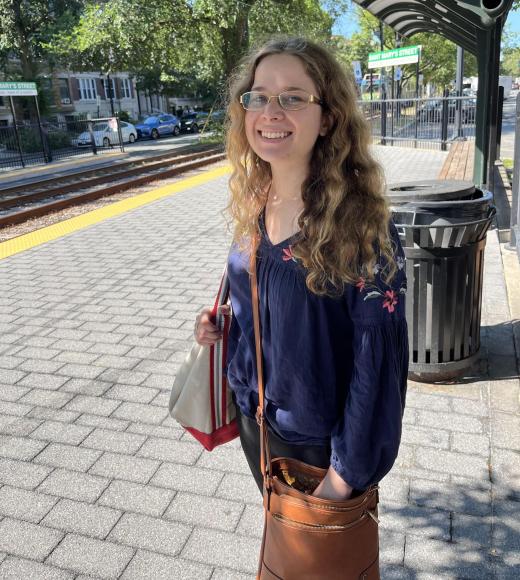 Emma smiles for the camera at a train station.