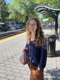 Emma smiles for the camera at a train station.