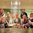 A group of students in front of a museum display of an ornate, branching mushroom ornament.