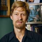 A man infront of a bookshelf